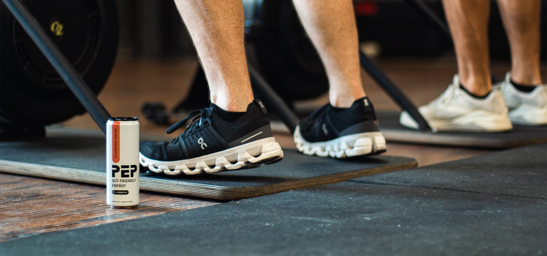 Person wearing black sneakers on a mat with a can of PEP product nearby.